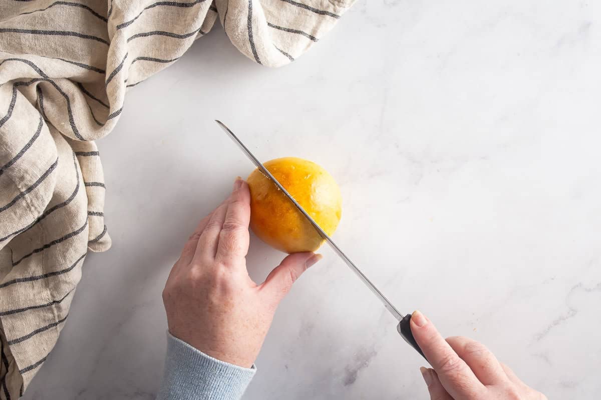 Splitting the maritozzi buns in half with a knife.
