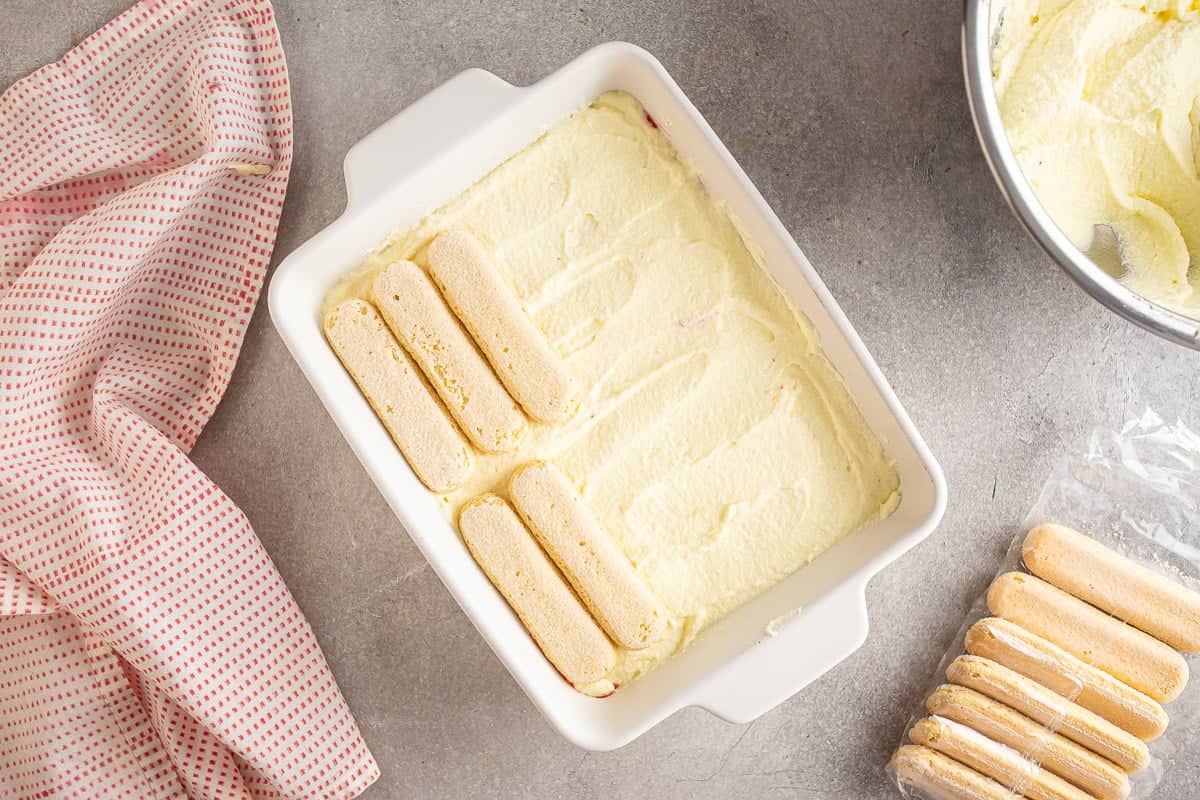 Layering ladyfingers onto the strawberry tiramisu.
