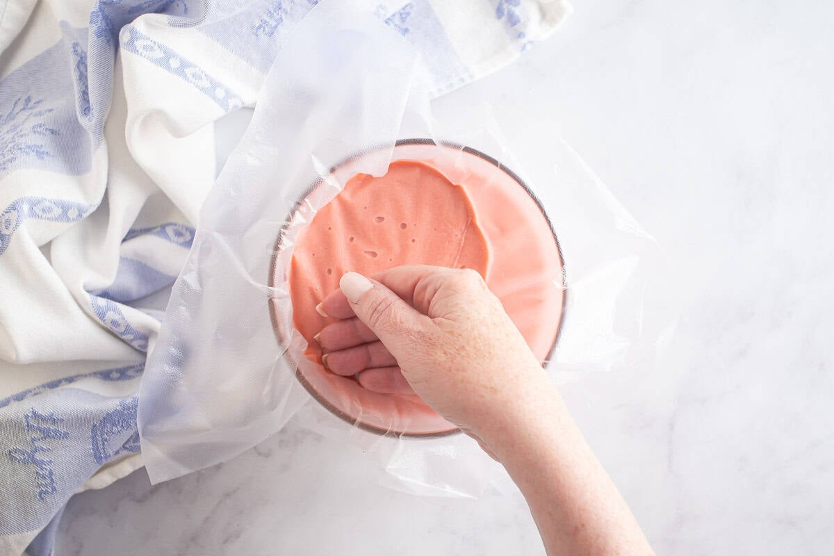 rhubarb curd covered with plastic wrap.
