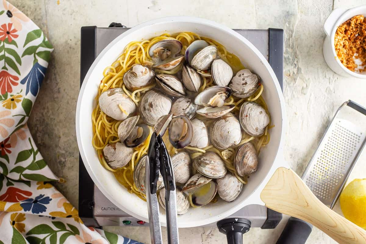 Adding fresh clams to linguine with clam sauce