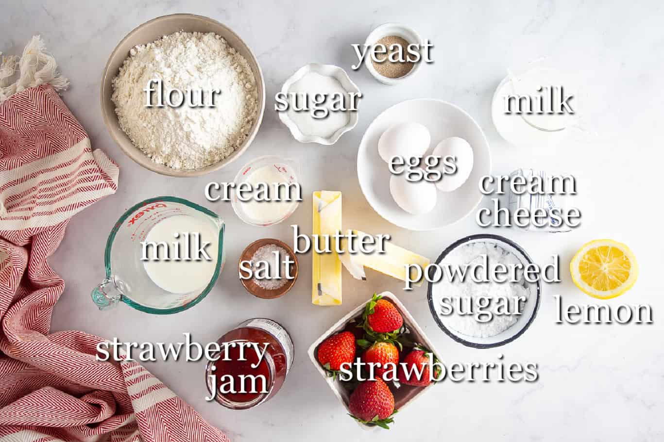 Ingredients for strawberry rolls in separate containers on a white background.