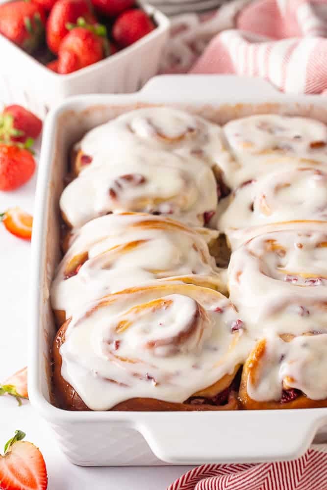 Strawberry rolls with icing in a white baking dish