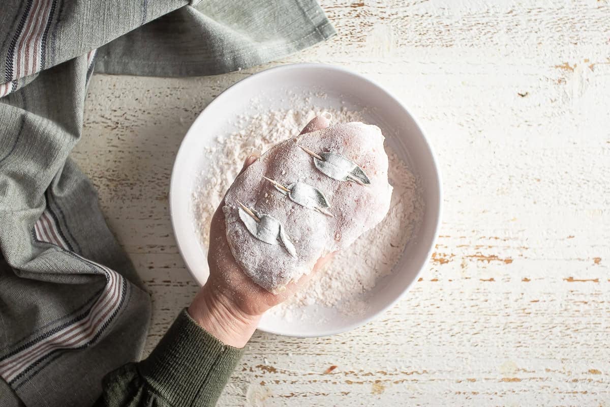 Both sides of a chicken breast for saltimbocca coated in flour.