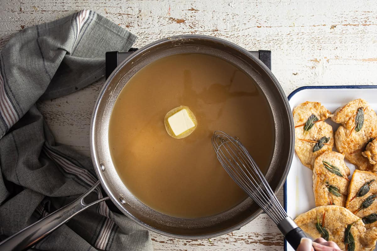 Adding butter to chicken saltimbocca sauce.