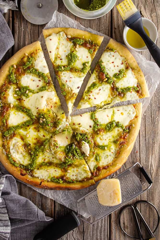 Pesto pizza from overhead with pieces cut out