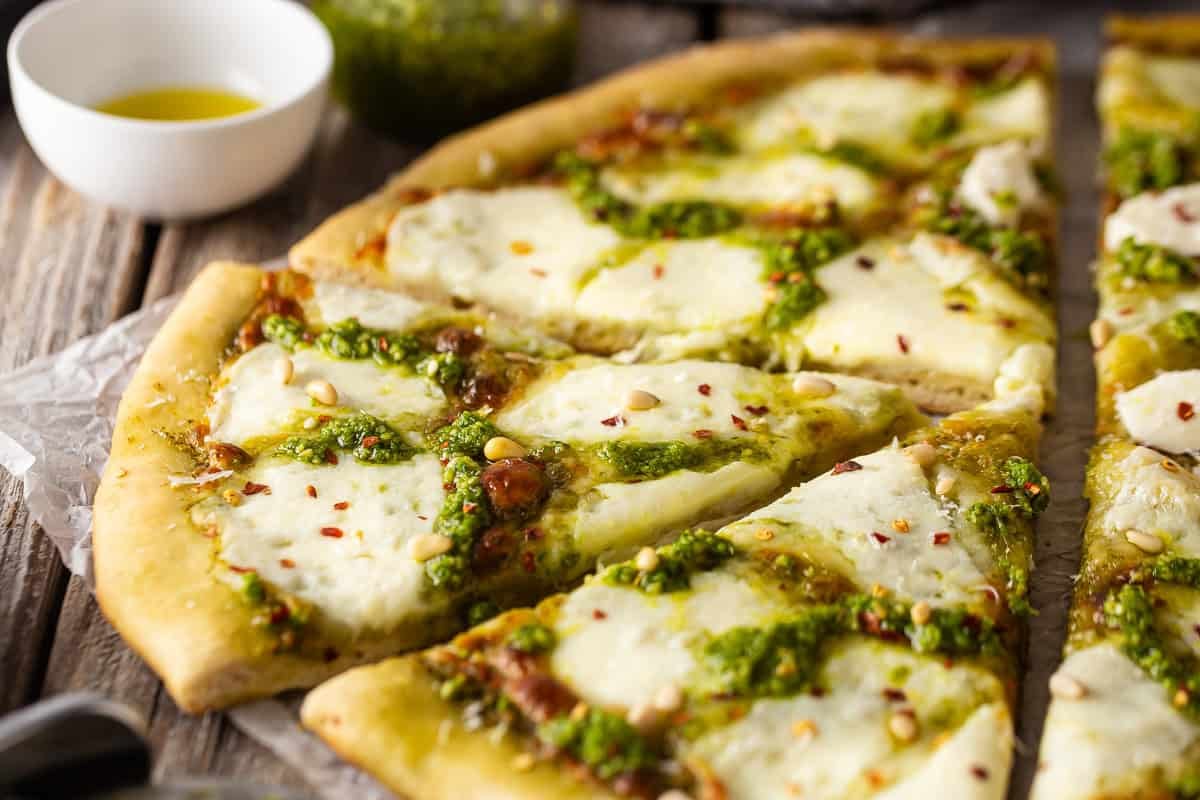 Pesto pizza cut into slices