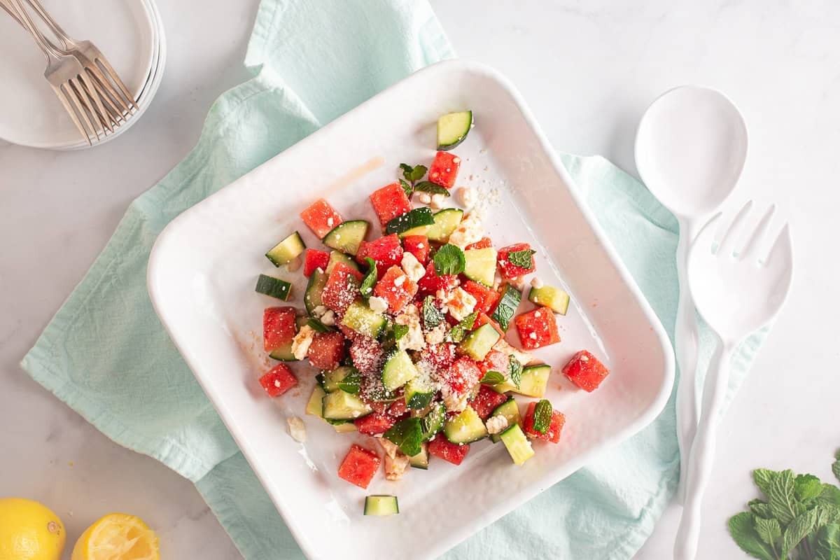Watermelon salad after being tossed and plated on a white plate.