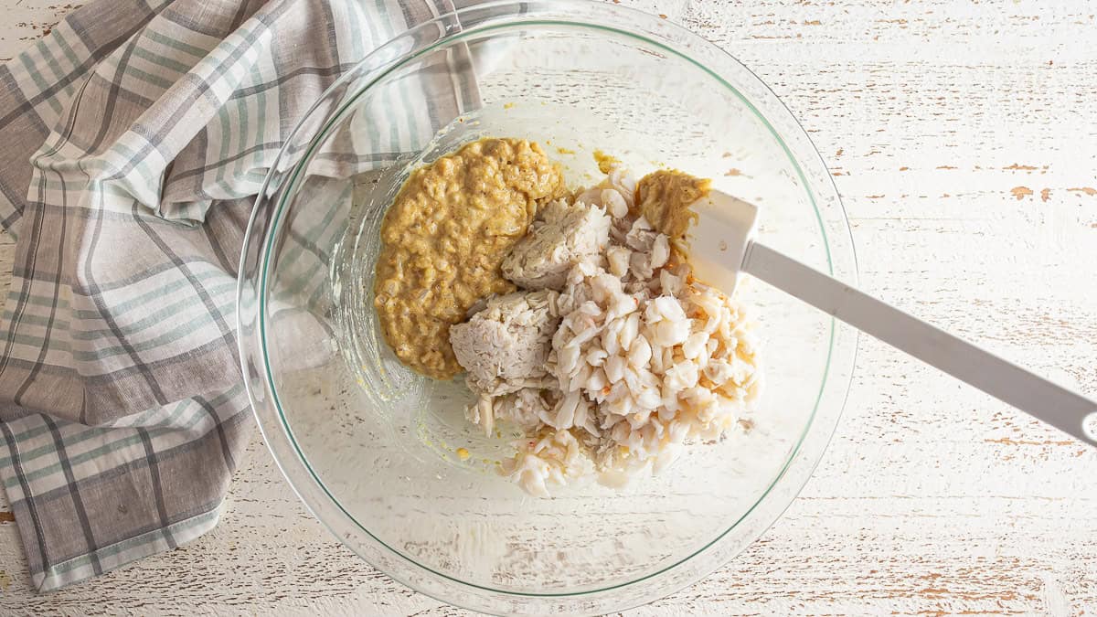 Adding crab to the crab cake binder