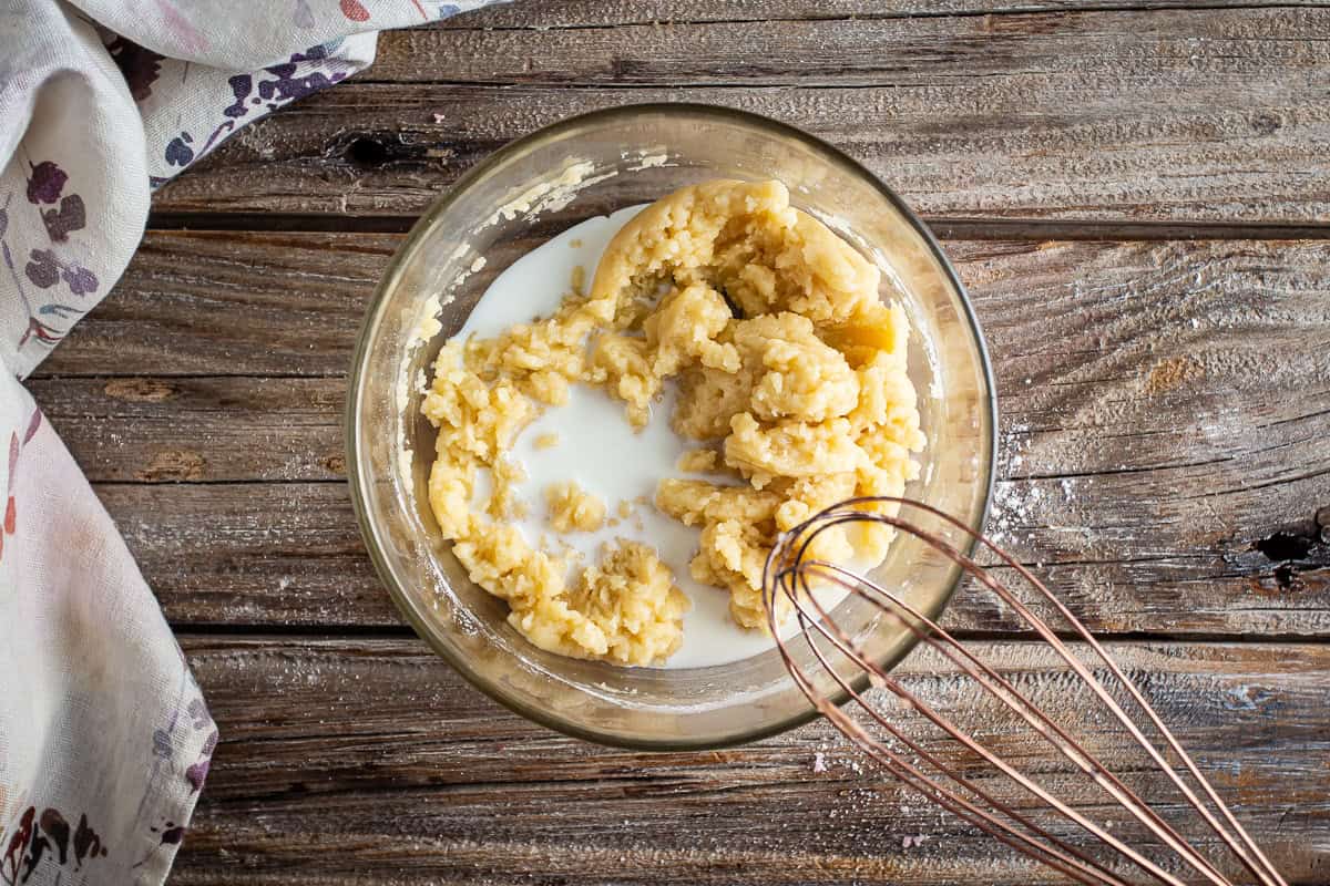 Adding milk to blackberry cobbler batter.