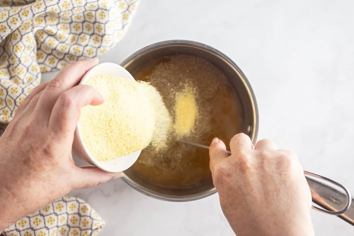 Whisking polenta into the chicken stock