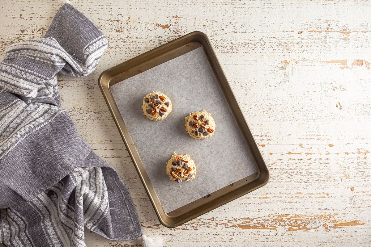 Unbaked cowboy cookies after being shaped into rounds and topped with extra toppings