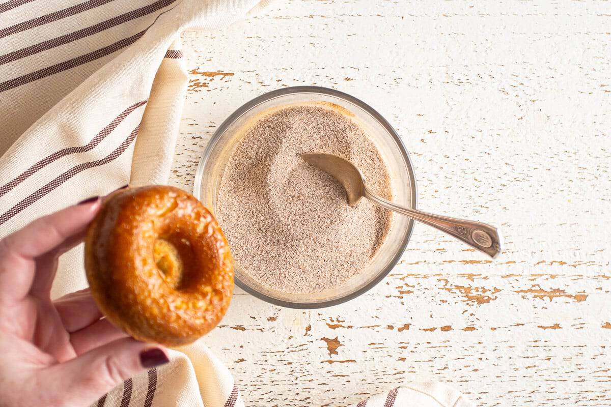 Coating baked donuts in cinnamon sugar