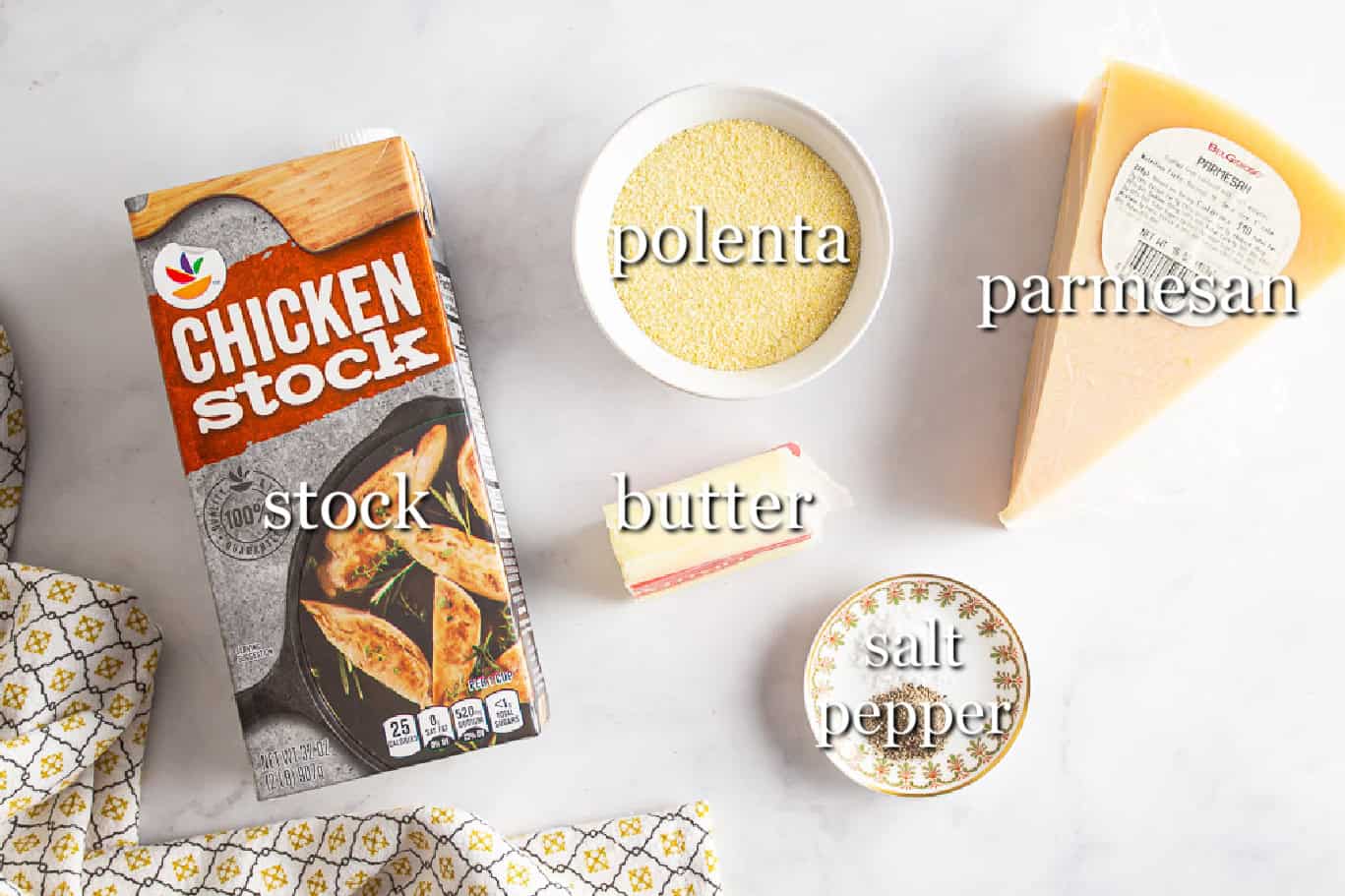 Ingredients for polenta in separate containers on a white background
