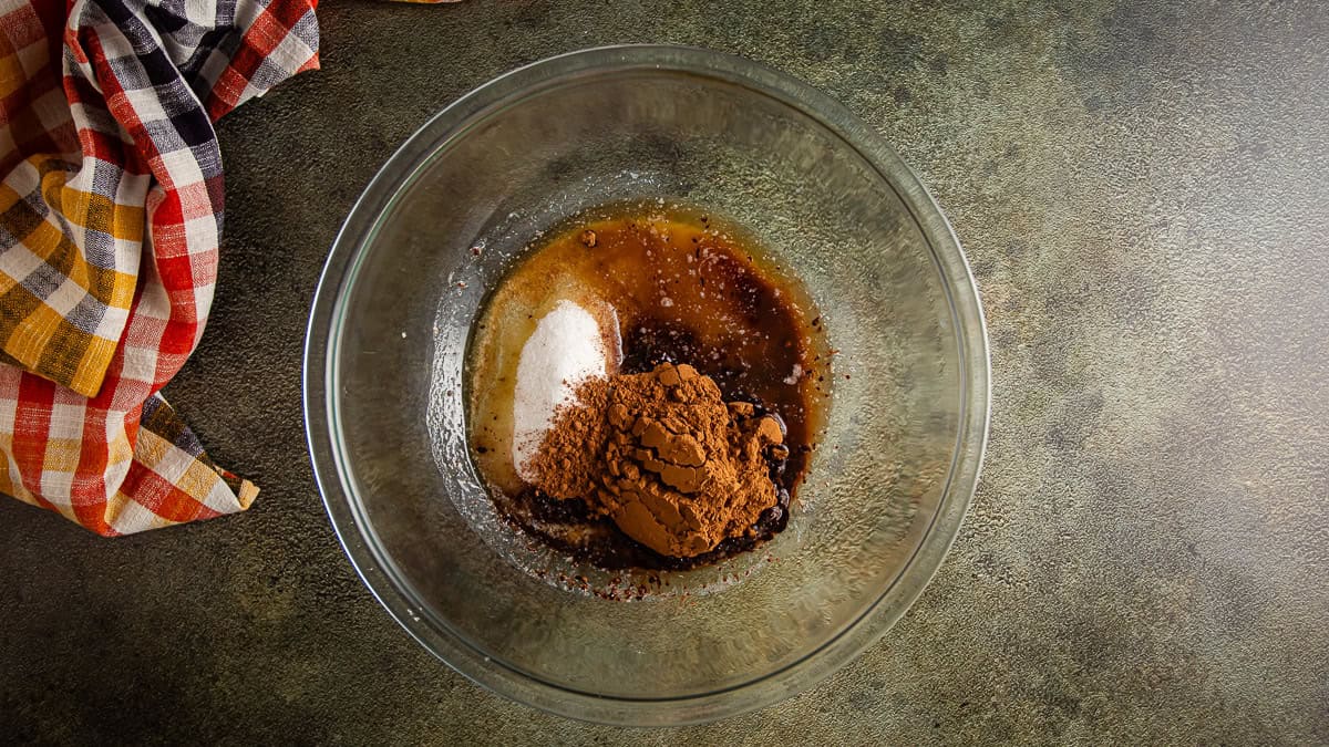 Sugar and cocoa with melted butter in a glass bowl