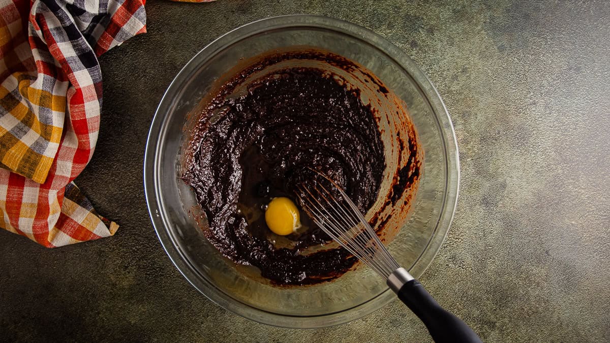 Adding egg to brownie batter