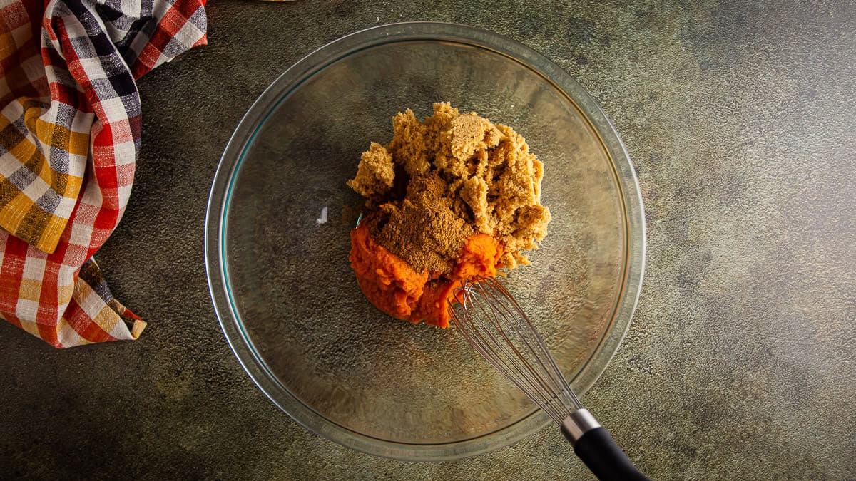 Pumpkin puree, sugar, and spices in a glass bowl