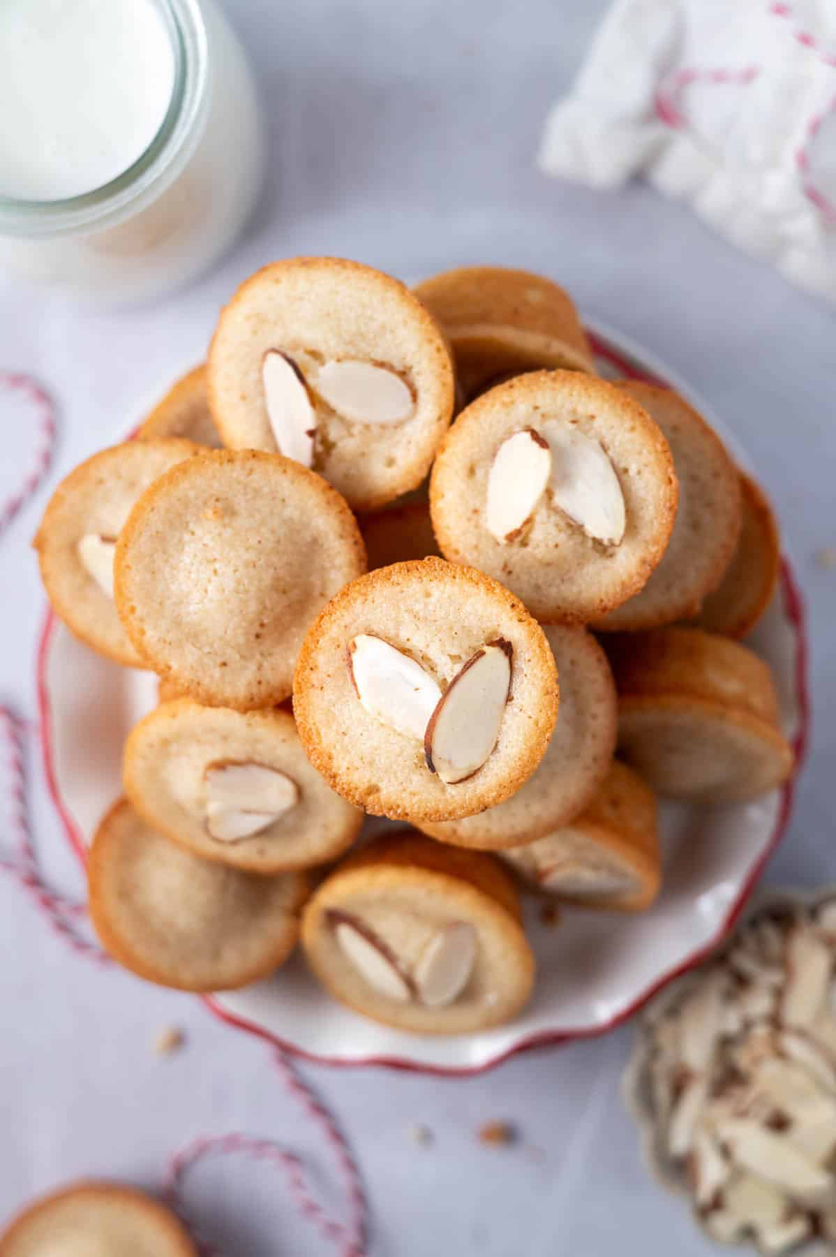 Financiers with almonds on top in a pile on a plate