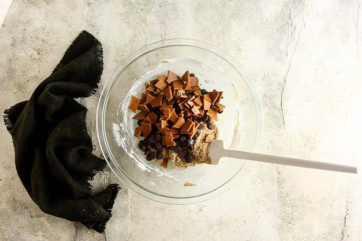 Adding chocolate chunks and toffee to the cookie dough mixture