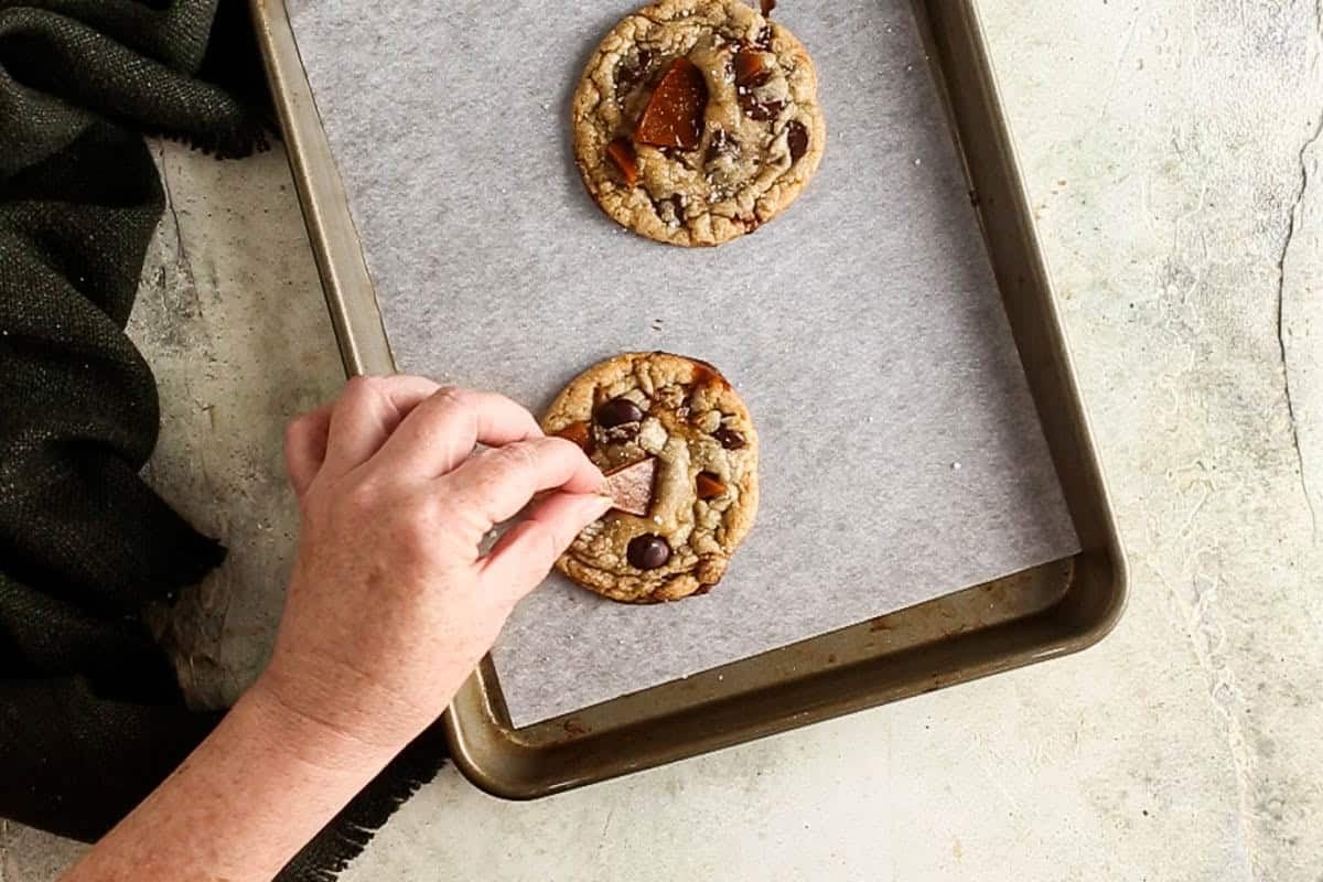 adding extra toffee and salt to the top of the baked cookies