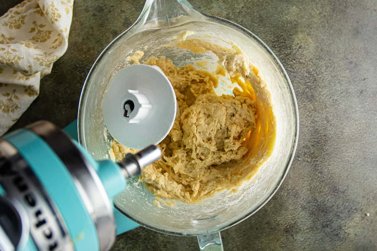 Mixing dough in a glass bowl with a stand mixer for Parker House Rolls.