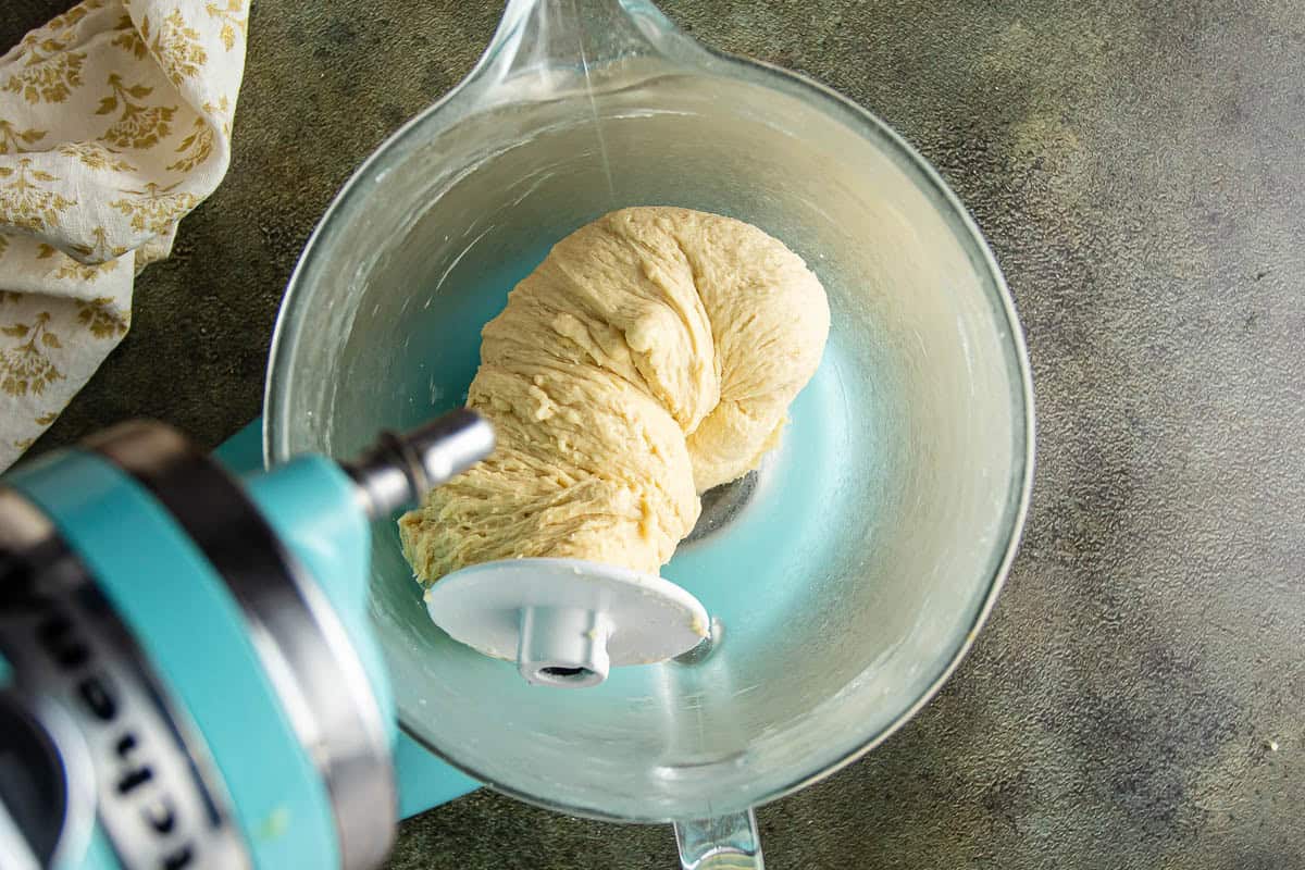 Dough being mixed in a glass bowl for Parker House Rolls.