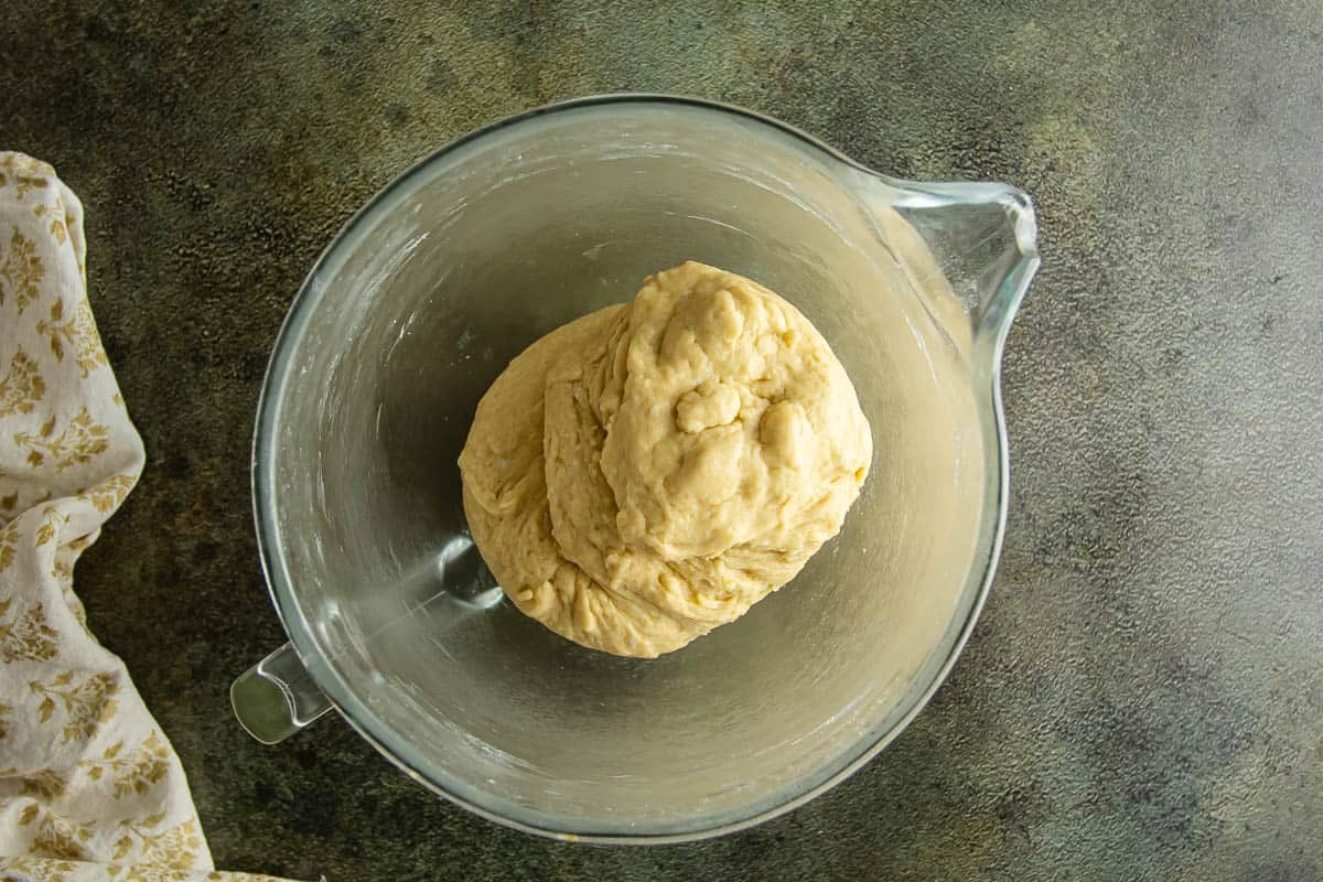 Dough ball in a glass mixing bowl for Parker House Rolls.