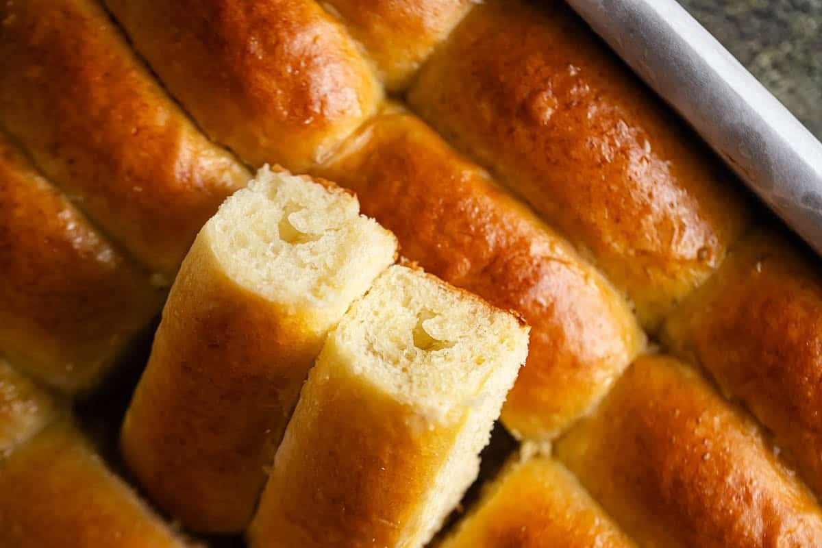 Close-up of freshly baked Parker House rolls with golden crust and soft interior.