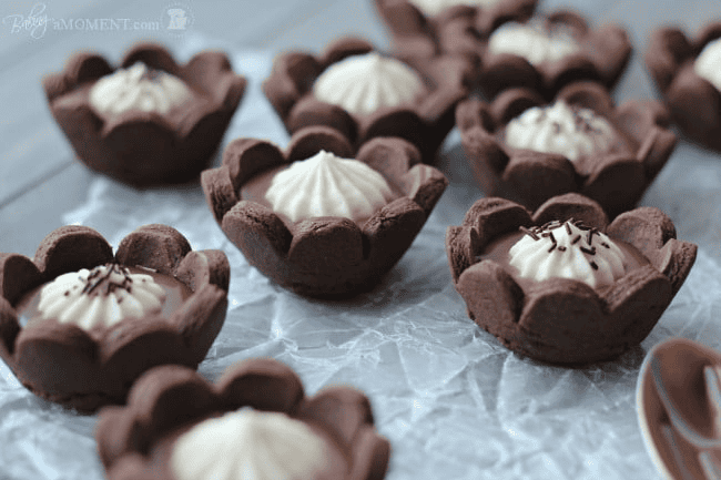 Chocolate cups with creamy filling and chocolate sprinkles on top.