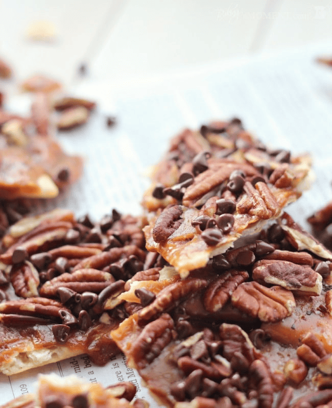 Chocolate pecan caramel bars on baking paper with a caramel drizzle.