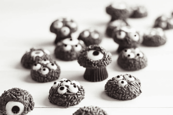 Chocolate eyeball cookies arranged on a white surface.