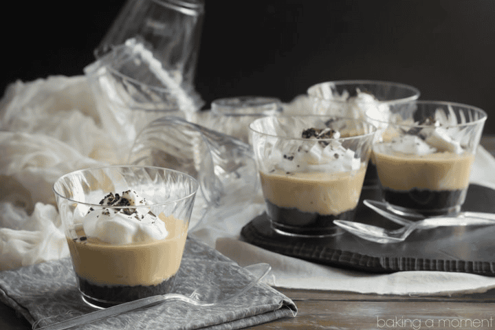 Delicious caramel dessert in glass cups with whipped cream and chocolate shavings.