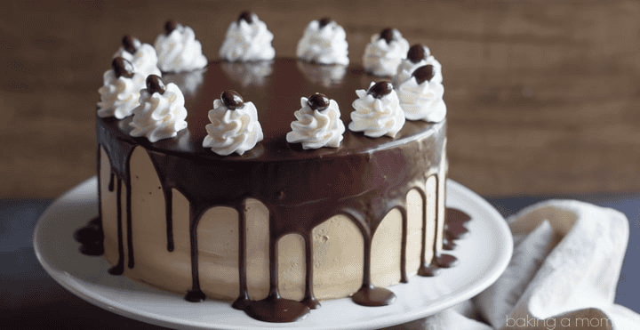 Chocolate and caramel cake with whipped cream and chocolate drizzle.