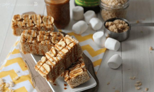 Caramel rice krispie treats with caramel drizzle on top, on a white plate.